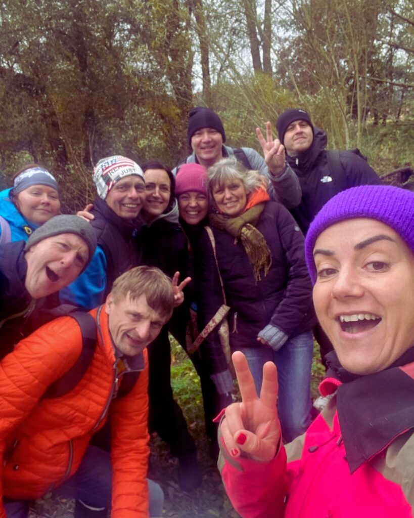 Teilnehmer*innen beim Eisbaden im Fluss, umgeben von Natur
